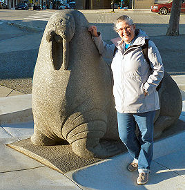 Claudia beim steinernen Walross vor dem Rathaus in Bodø